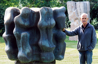 Photo Künstler neben einer Skulptur