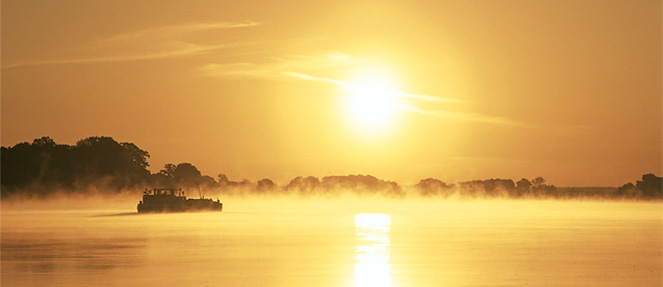 Photo Sonnenaufgang über der Elbe mit einem Boot